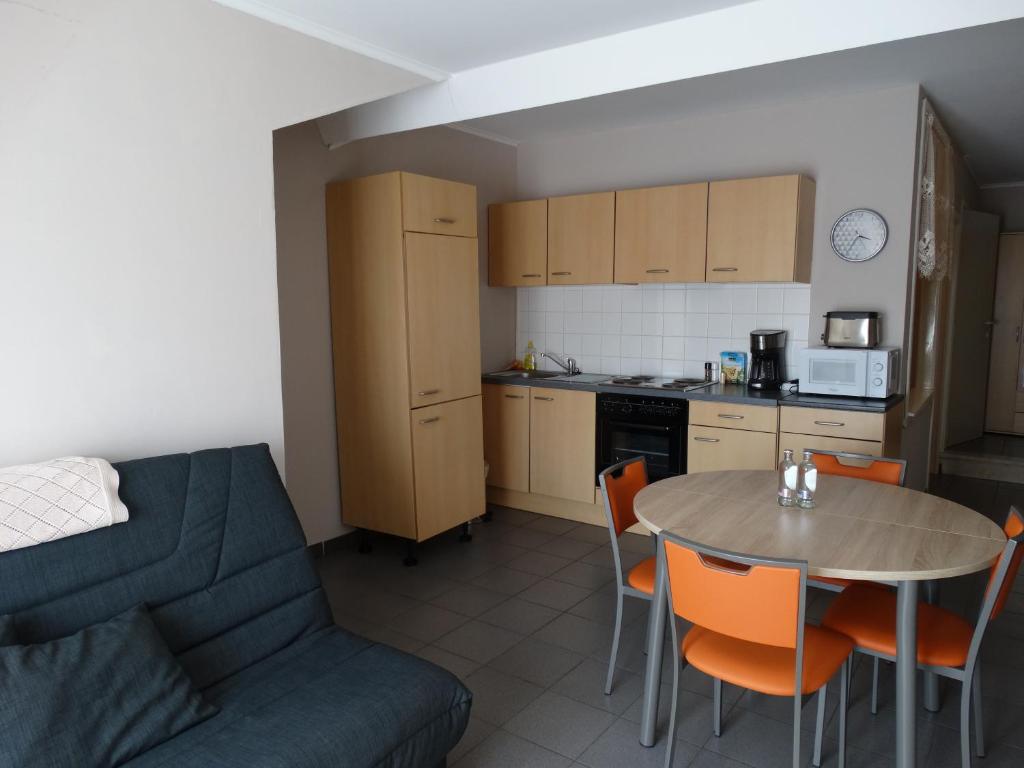 een keuken en een woonkamer met een tafel en een bank bij Vakantieverblijf Berg en Dal in Heuvelland