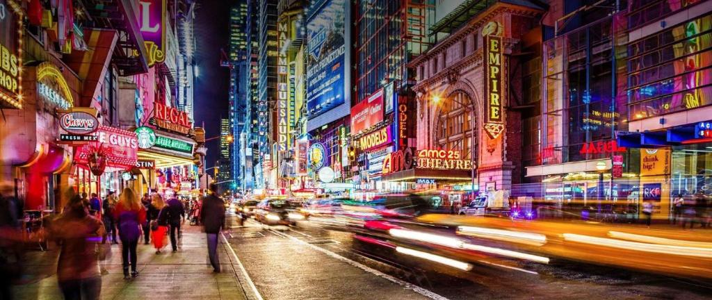 Una calle concurrida de noche con coches en Hudson River Hotel en Nueva York