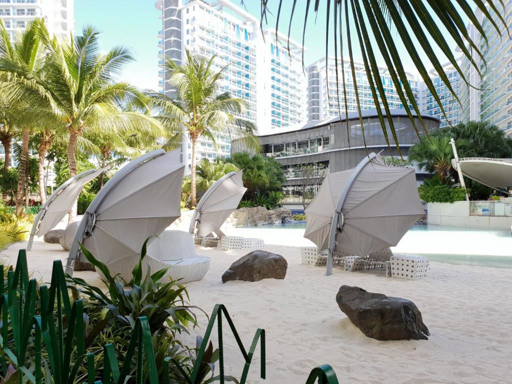 a group of umbrellas on a beach with buildings at Manila Urban Resort at Azure in Manila