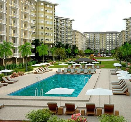 a swimming pool with chairs and umbrellas and buildings at Affordable condotel near Manila Airport in Manila