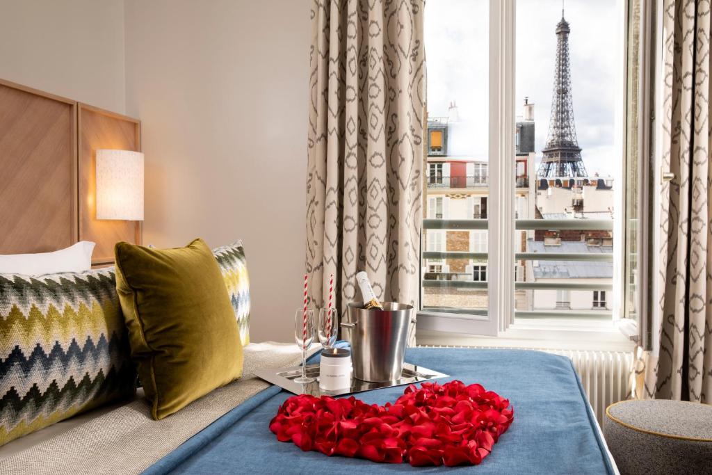 una sala de estar con una mesa con rosas rojas. en Jardins Eiffel, en París