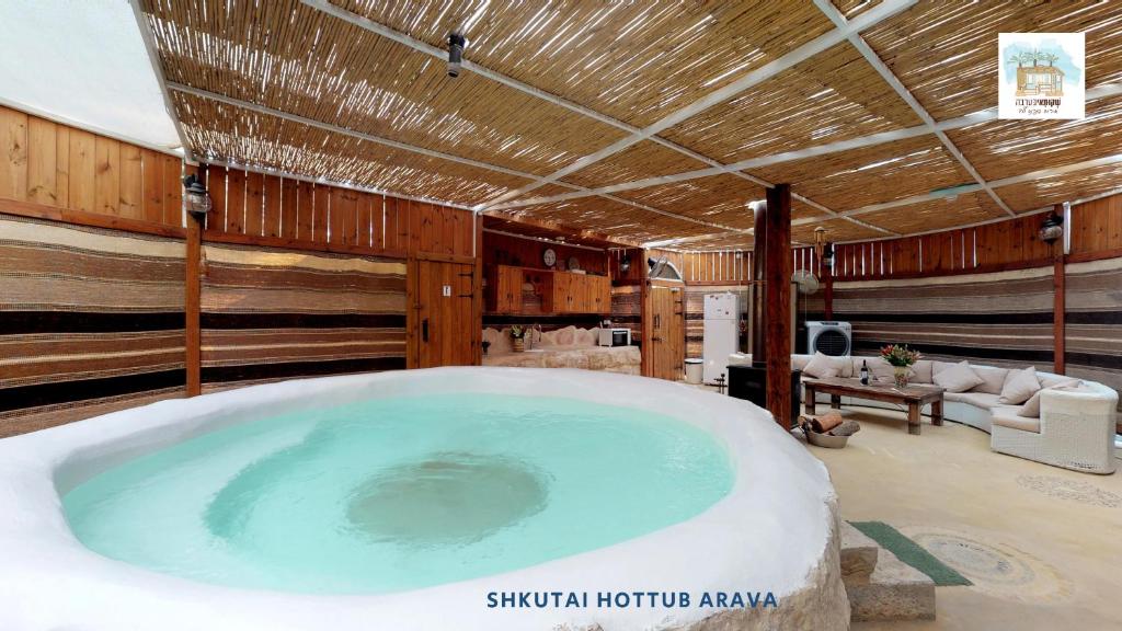 uma grande banheira de hidromassagem num quarto em Shkutai Hottub Arava em Ẕofar