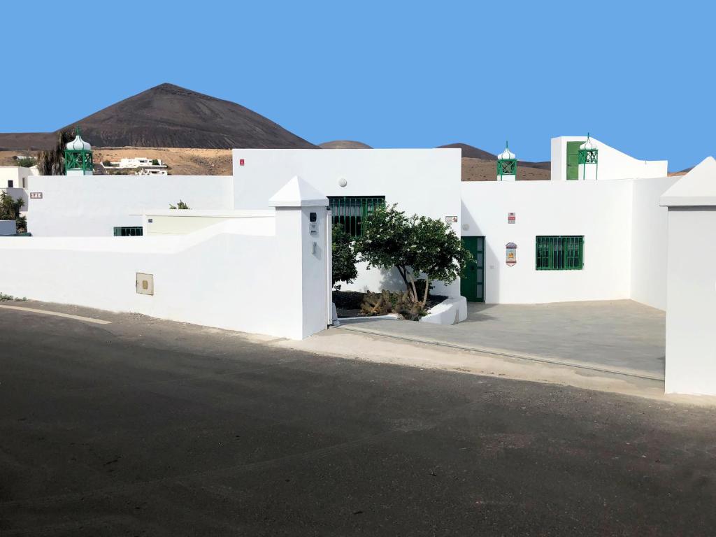 a white house with a driveway and a mountain in the background at LOS ABUELOS in Tías