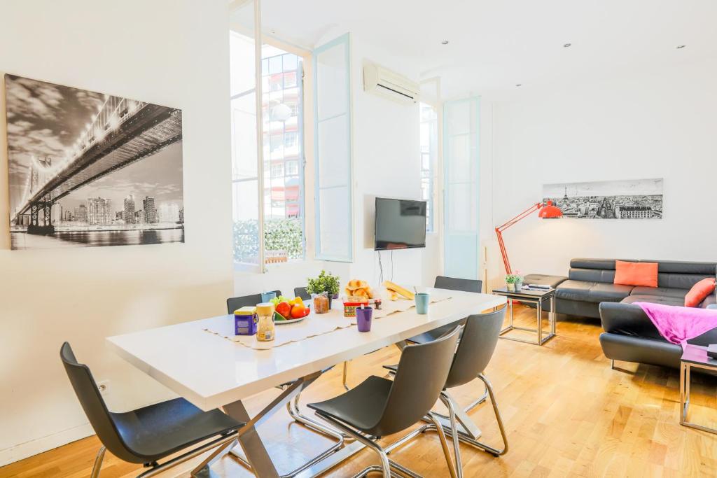 un salon avec une table et des chaises blanches dans l'établissement CARRE D'OR TERRACE AP4015 NICE by Riviera Holiday Homes, à Nice