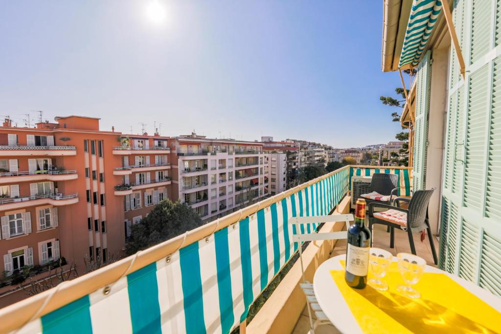 Una botella de vino sentada en una mesa en un balcón en VILLA DUBOUCHAGE AP2066 - Nice, by Riviera Holiday Homes, en Niza