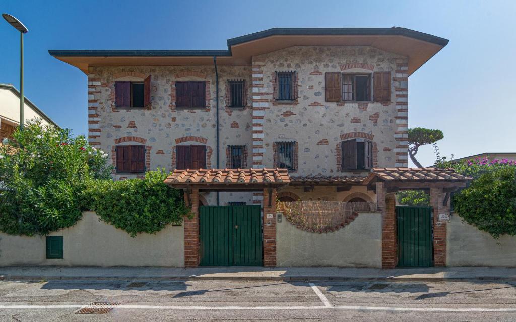 a building with a green gate in front of it at Villa Il Fortino in Lido di Camaiore