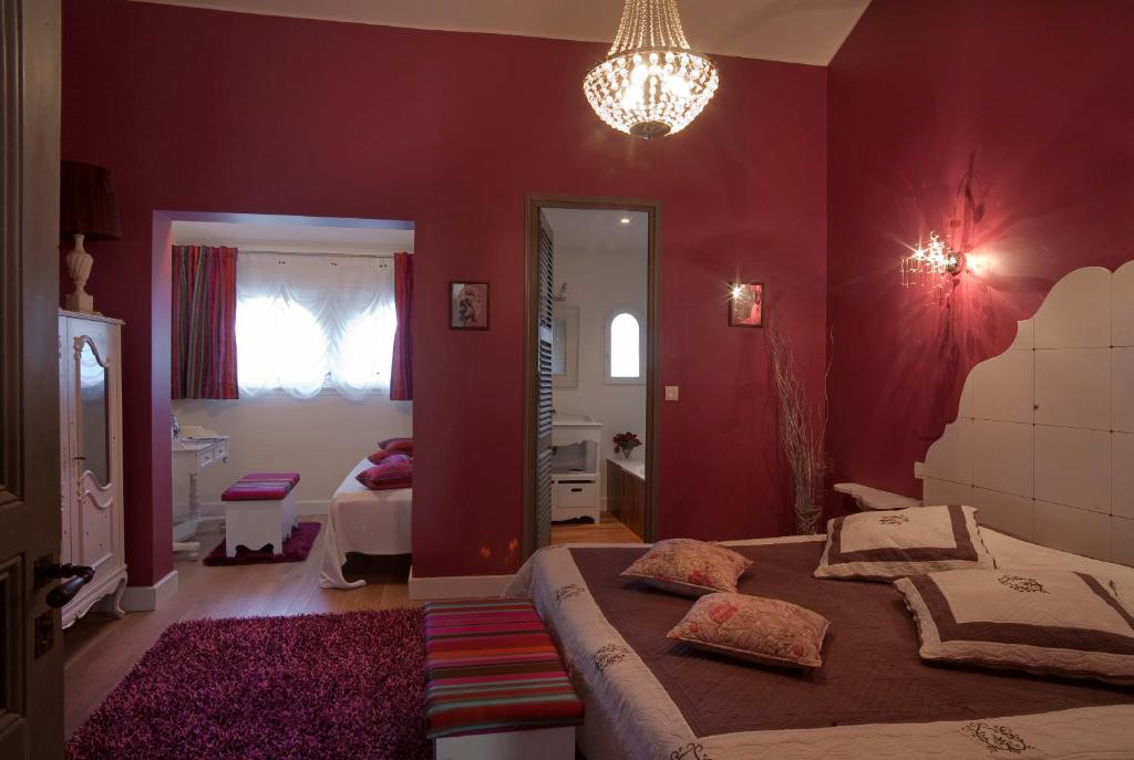 a bedroom with a large bed and a chandelier at Bed & Breakfast Demeure du Pareur in Villeneuve-Minervois