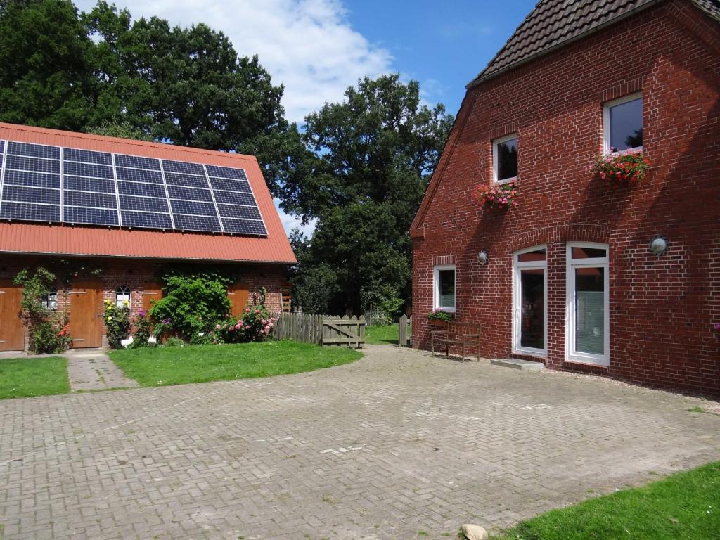 a brick house with a building with solar panels on it at Hof Sonnengold in Osterholz-Scharmbeck