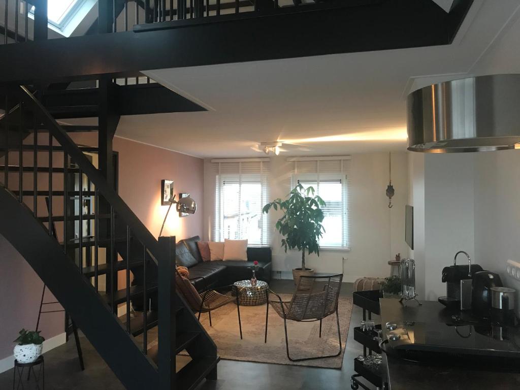 a living room with a staircase and a couch at Pakhuis 5 in Katwijk aan Zee