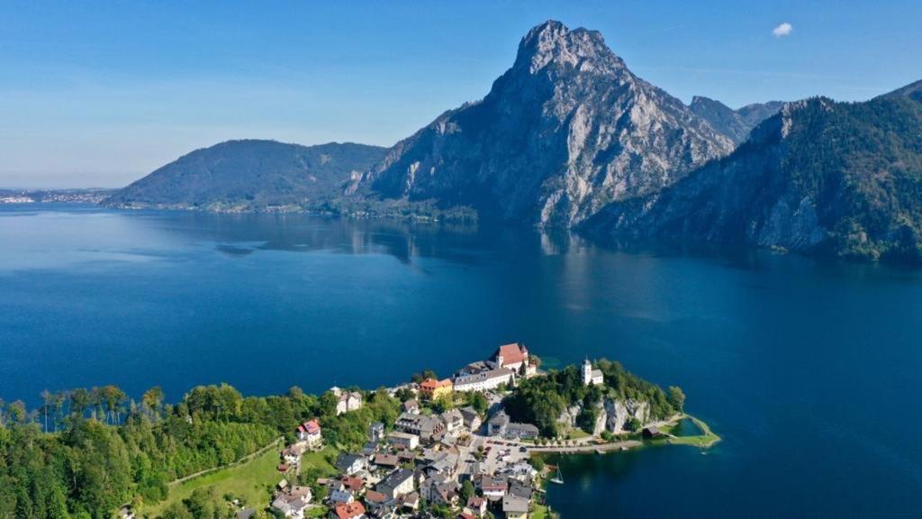 an island in the middle of a lake with mountains at Charming Apartment with Mountain View in Altmünster