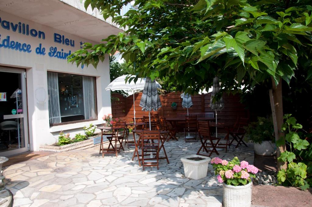 een groep stoelen en tafels buiten een restaurant bij Le Pavillon Bleu Hotel Restaurant in Royan
