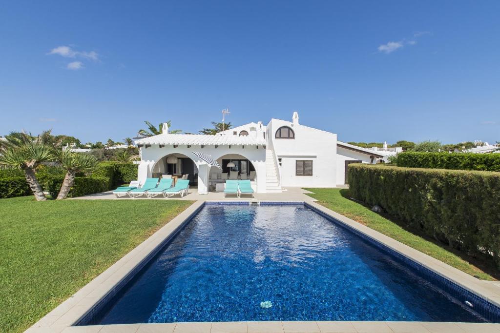 a villa with a swimming pool in front of a house at Villa Bini Andu in Binibeca