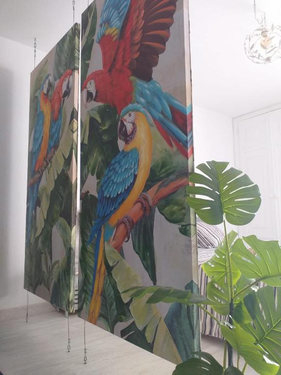 a painting of colorful parrots on a wall at Tropical Loft in Corralejo