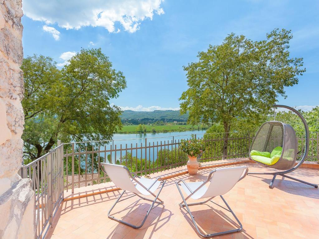 eine Terrasse mit 2 Stühlen, einem Tisch und einem Spiegel in der Unterkunft La Casa Sul Lago in Posta Fibreno