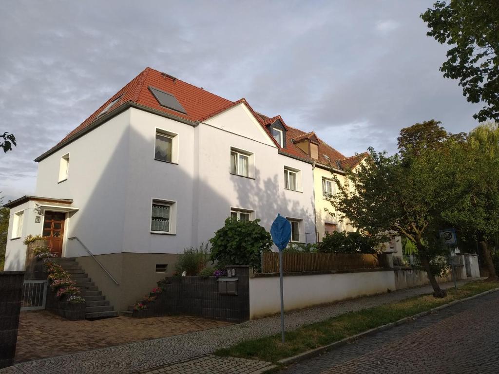 a white house with a red roof at Ferienwohnung Familie Bulst in Naumburg