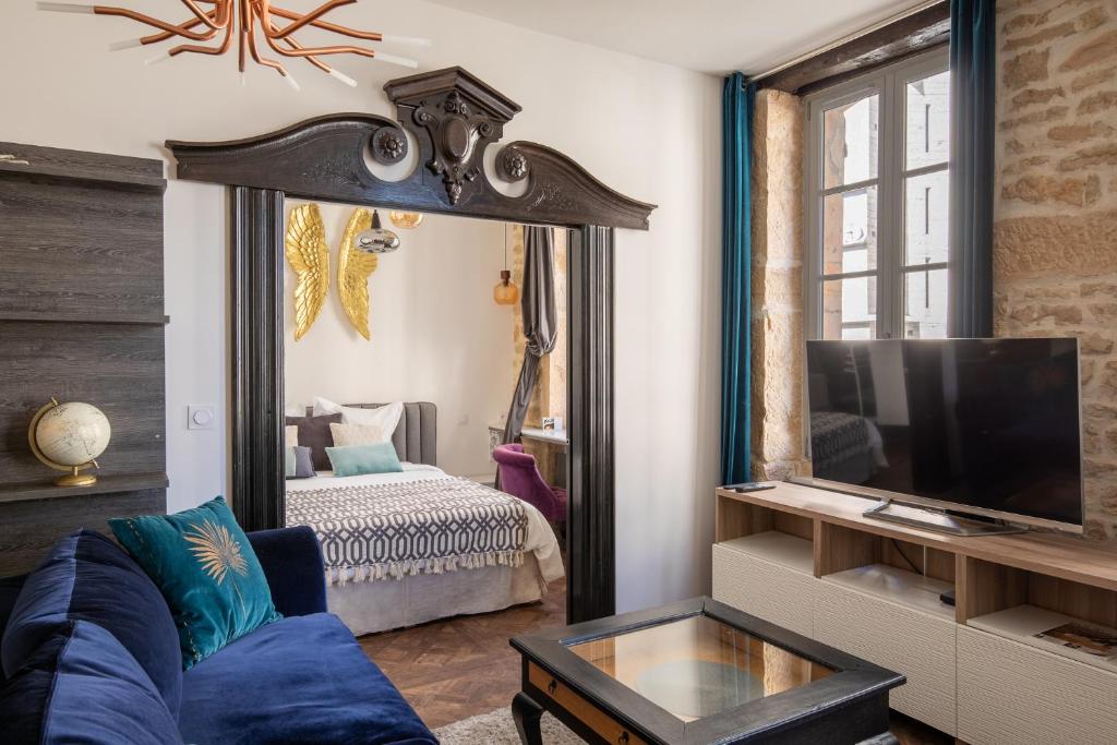 - un salon avec un canapé bleu et un grand miroir dans l'établissement La Suite Indivio - Appartement standing vue cathédrale, à Dijon