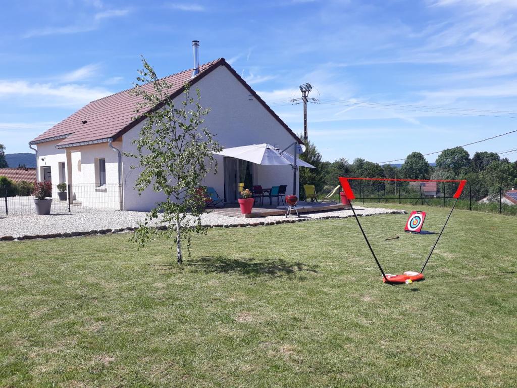 einem roten Frisbee in einem Hof vor einem Haus in der Unterkunft Entre Lacs Et Montagnes , Maison individuelle, lits préparés et ménage inclus in Barésia-sur-lʼAin