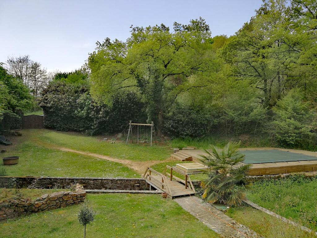 un jardin avec une aire de jeux et un appareil de sport dans l'établissement Dolce Vita, à Montfaucon