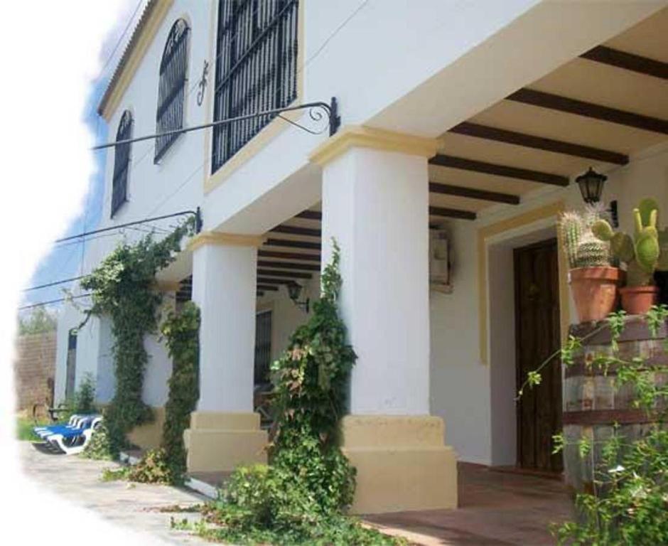 uma casa branca com plantas ao lado dela em Casa Cantarrana em Arriate