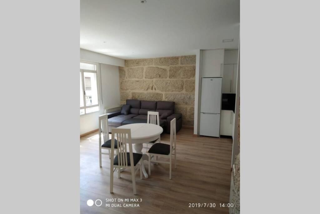 cocina y sala de estar con mesa y sofá. en Villa Trabazos Abellas, en Ourense