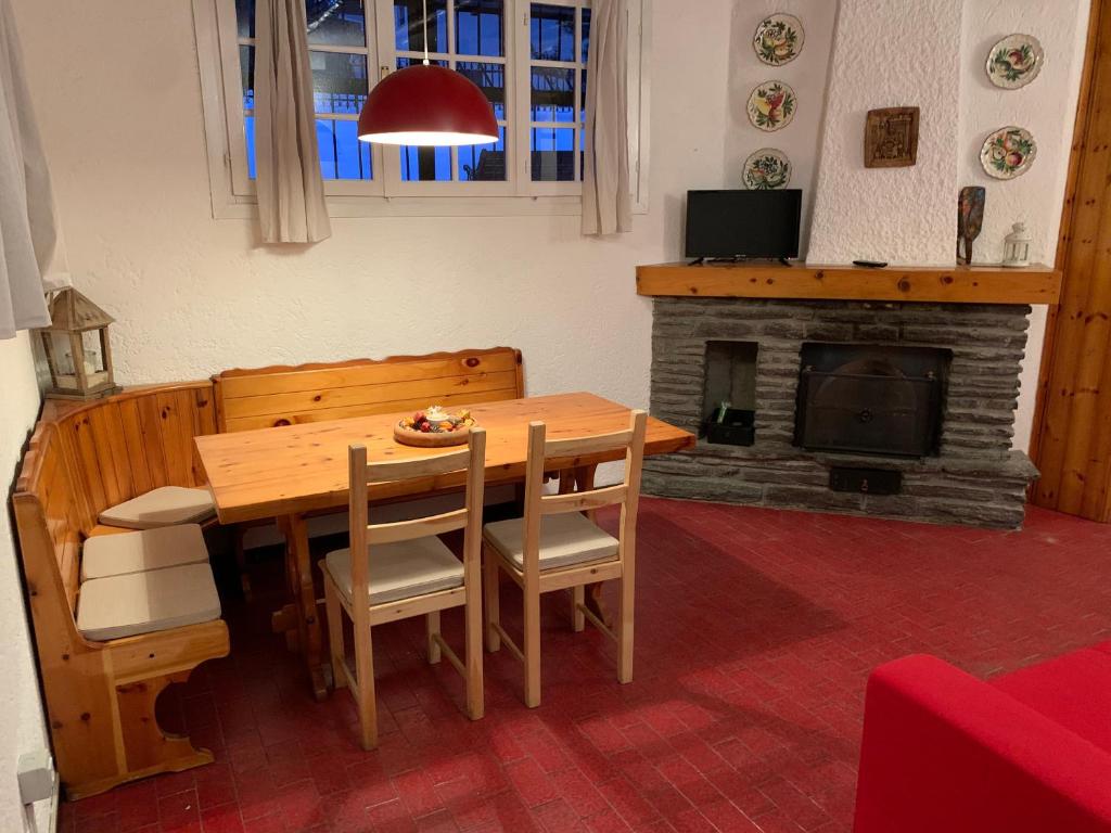 a dining room with a table and a fireplace at Ridge Line in Ponte di Legno