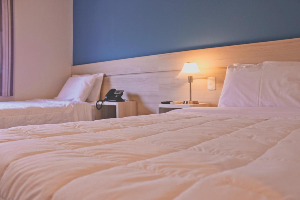 Postel nebo postele na pokoji v ubytování Nova Hotel