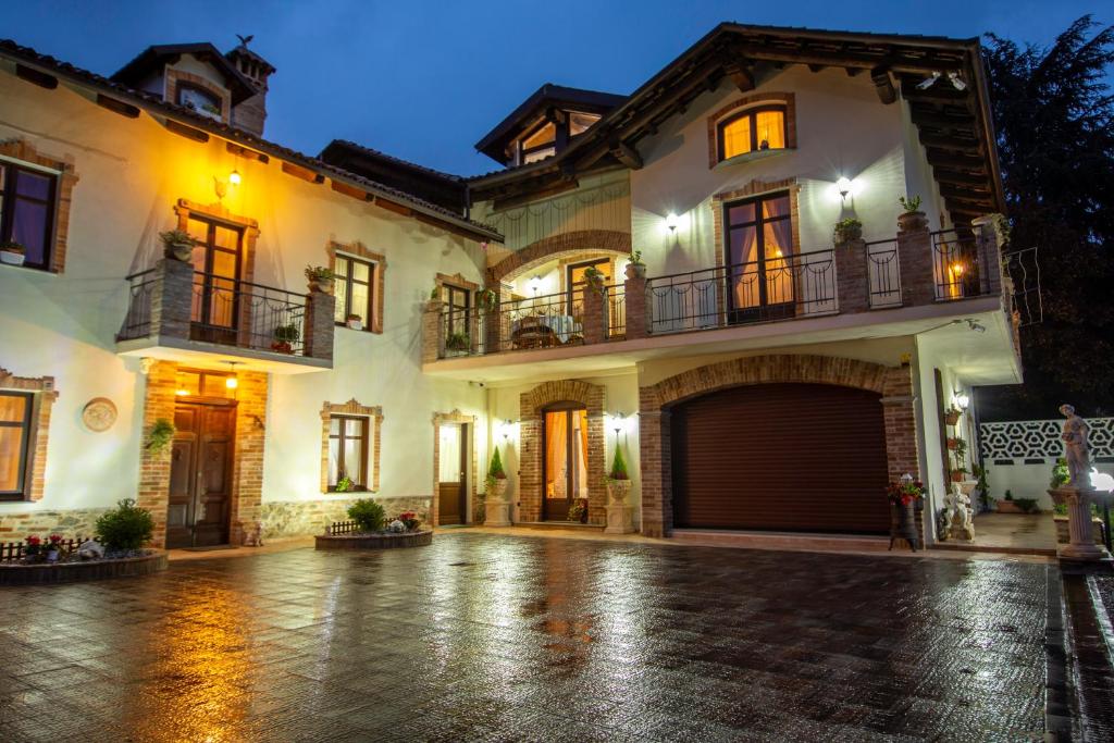 a large white house with a garage at night at Cà Reginella B&B in Diano dʼAlba