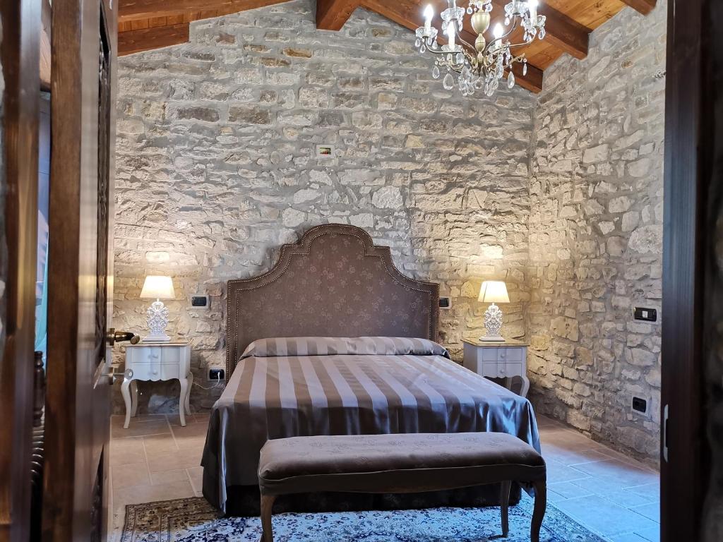 a bedroom with a large bed in a stone wall at L'Antica Dimora - Suites & Apartments in Màndas