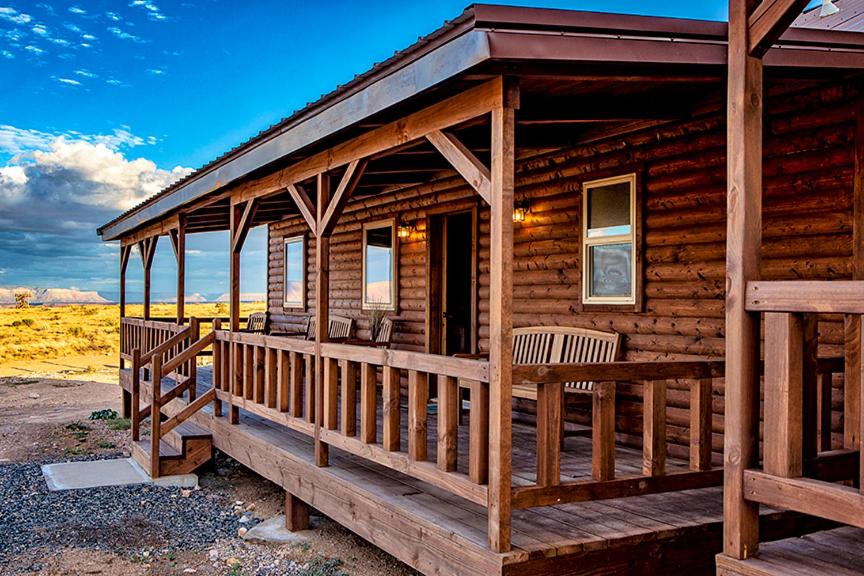 a log cabin with a porch and two chairs at Cabins at Grand Canyon West in Peach Springs