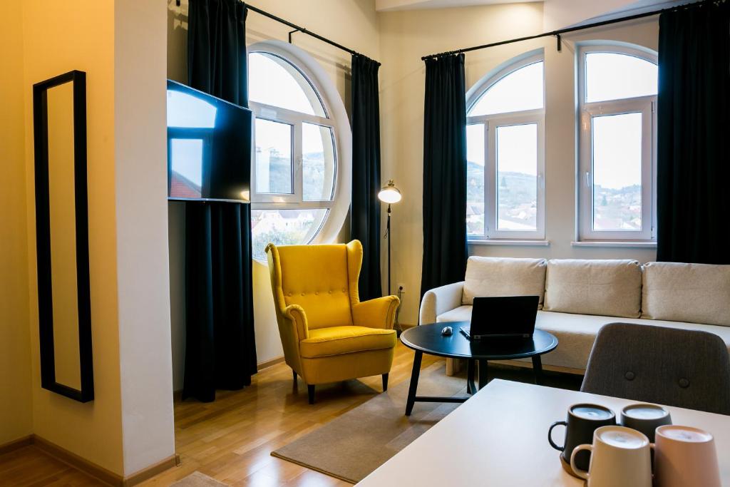 een woonkamer met een bank en 2 ramen bij NORDIC Home in Deva