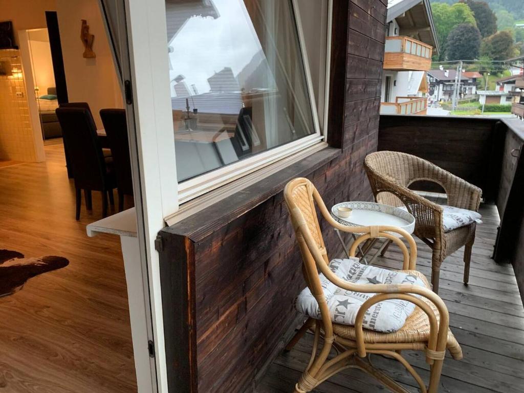 a porch with two chairs and a window at Hornhaus in Kitzbühel