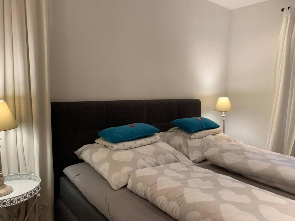 a bedroom with two beds with blue pillows on them at Hornhaus in Kitzbühel