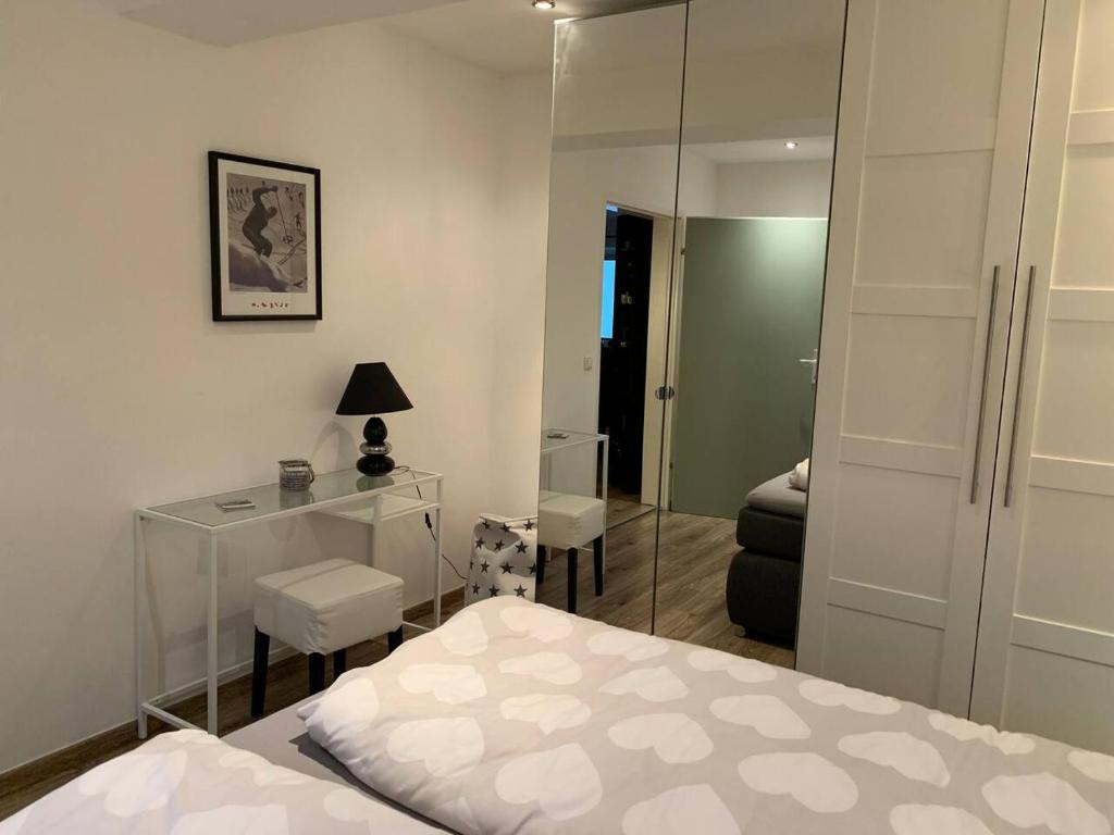 a bedroom with a bed and a desk and a mirror at Hornhaus in Kitzbühel