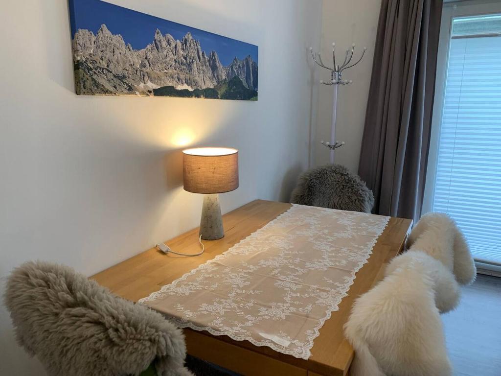 a dining room table with a lamp and two dogs at Hornhaus in Kitzbühel