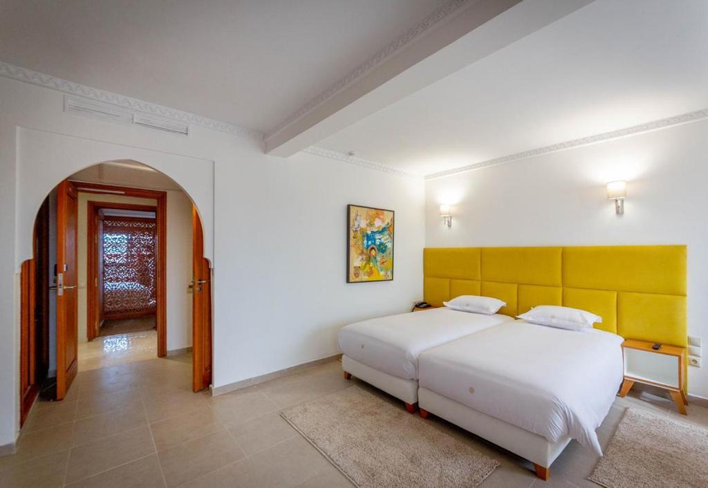 Postel nebo postele na pokoji v ubytování Hôtel Ibn Batouta