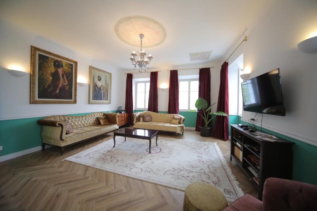a living room with a couch and a tv at Vitez Apartment I in Ljubljana