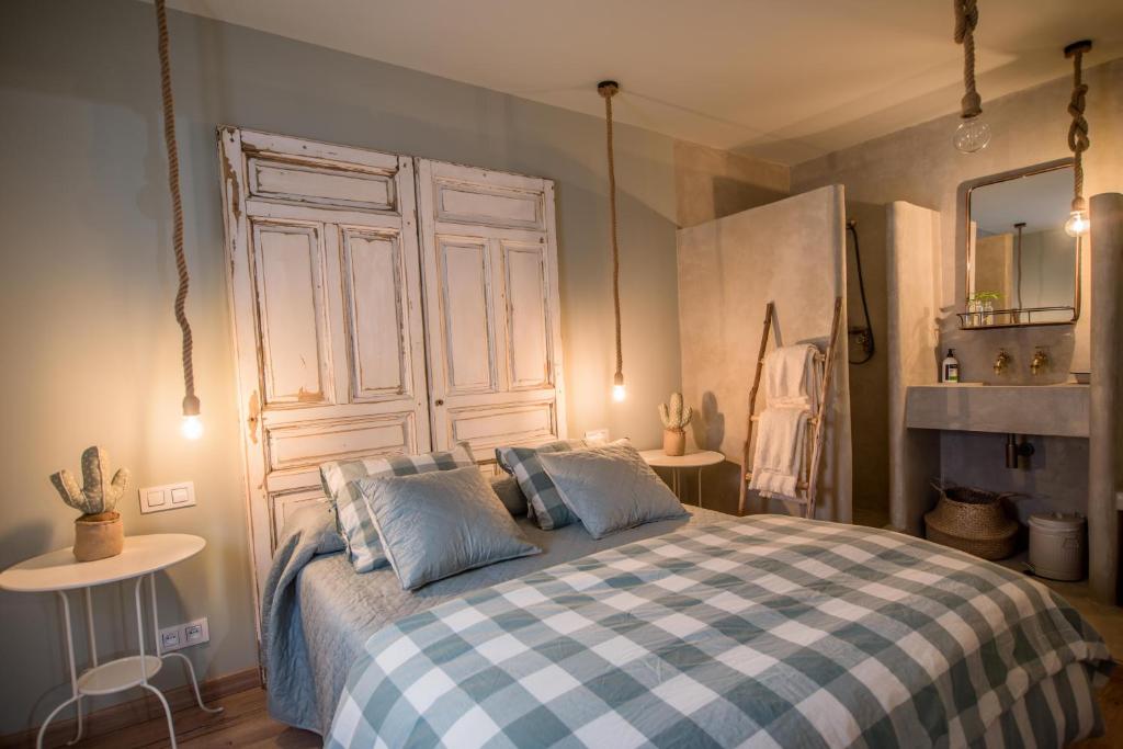 a bedroom with a bed with a blue and white checkered blanket at La Casita de Candela Toledo in Toledo