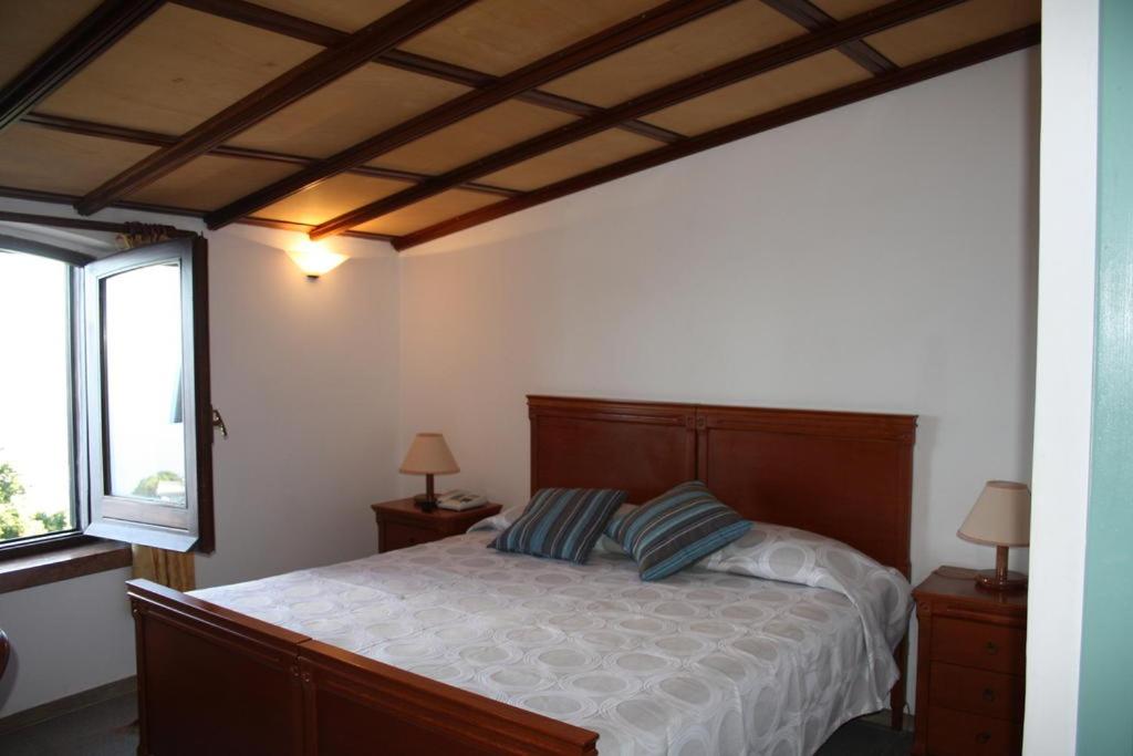 1 dormitorio con 1 cama grande y 2 ventanas en Hotel Edelweiss, en Erice