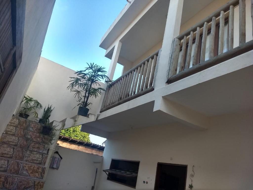 einen Balkon eines Hauses mit zwei Topfpflanzen in der Unterkunft Casa Nice Trancoso in Trancoso