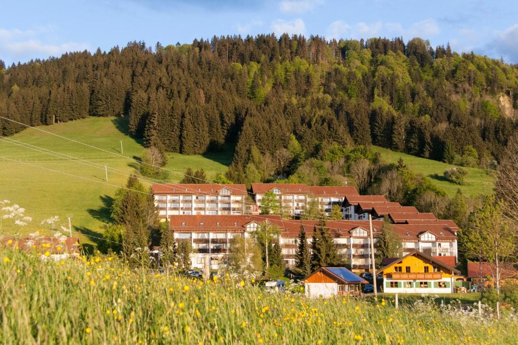 ein Gebäude auf einem Hügel neben einem Berg in der Unterkunft Ferienpark Oberallgäu - Invest Freizeit in Missen-Wilhams