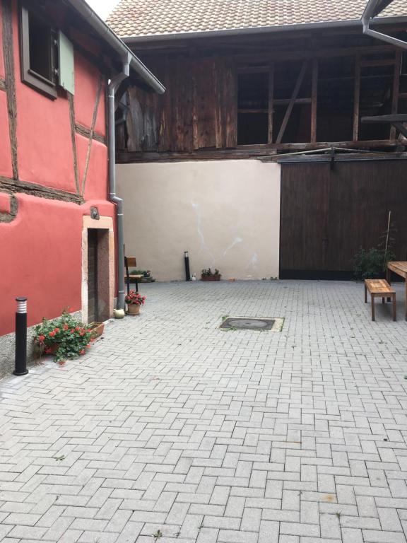 un patio con un edificio rojo y blanco en Gîte de l'ours grognon, en Dambach-la-Ville