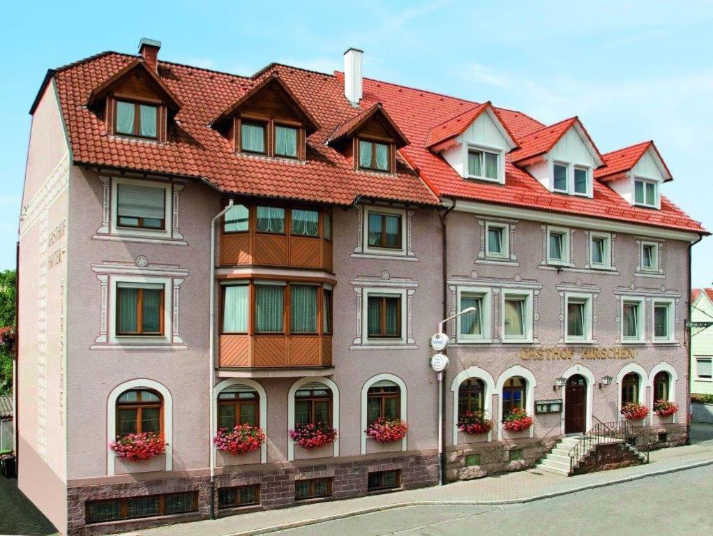 un gran edificio con techo rojo en Hotel Restaurant Zum Hirschen, en Donaueschingen