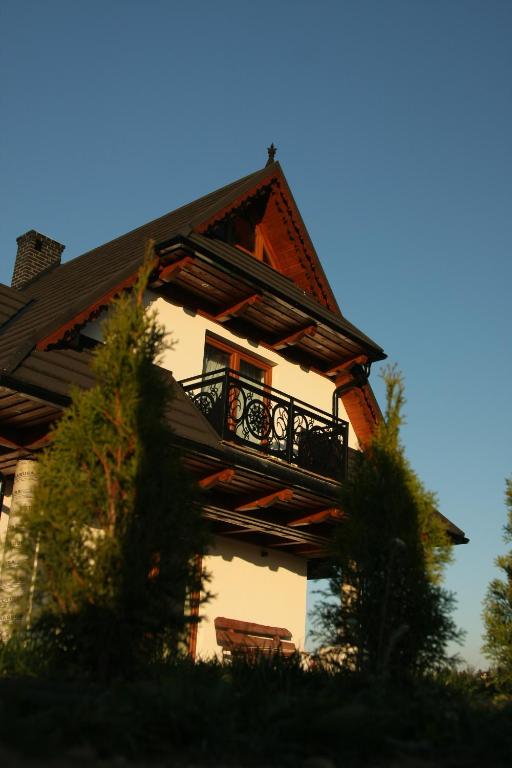 una casa con un balcón en el lateral. en Domek Liszkówka en Ratułów