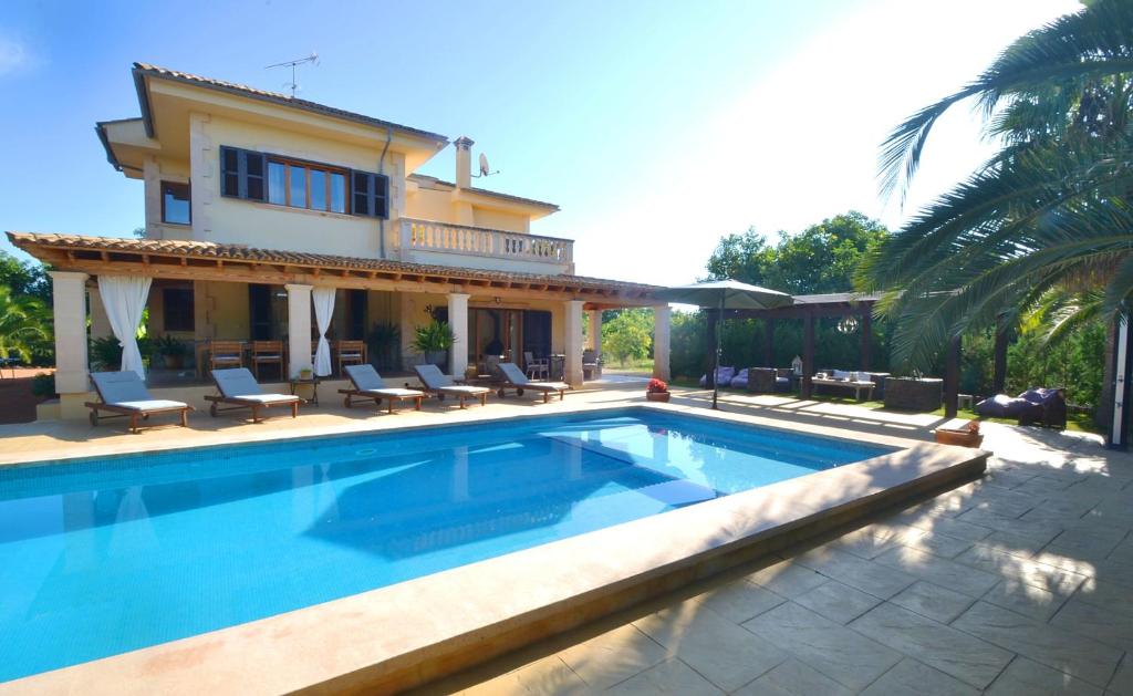 eine Villa mit einem Pool vor einem Haus in der Unterkunft Caricuao house in Plamanyola