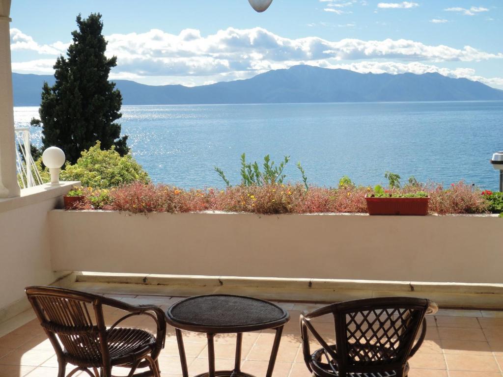 2 Stühle und ein Tisch auf dem Balkon mit Blick auf das Wasser in der Unterkunft Apartments Sea View - cosy & comfortable in Brist