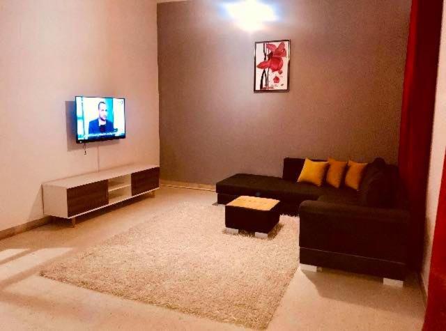 a living room with a couch and a flat screen tv at Appartement Manzah 6 in Ariana