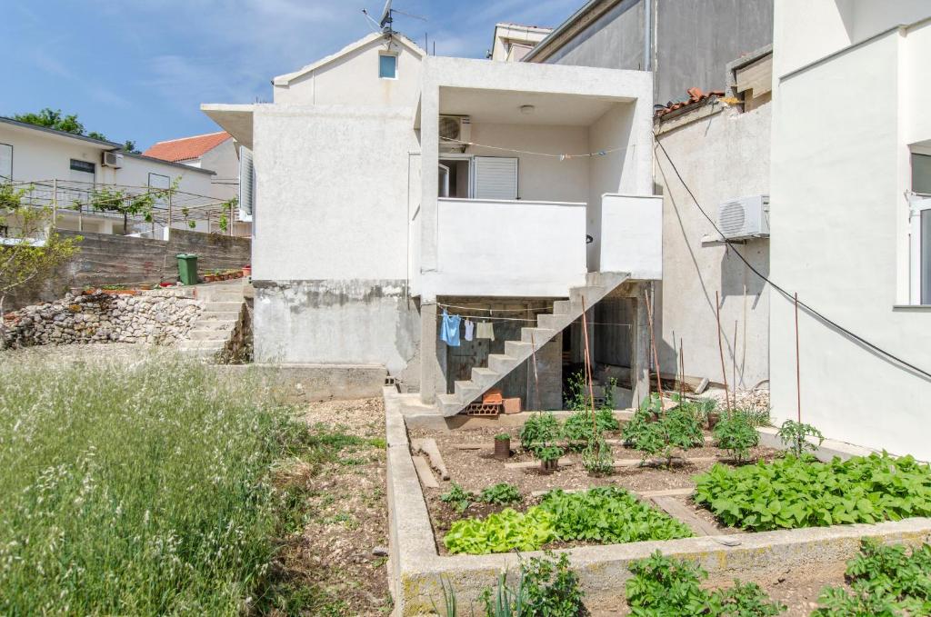 a house with a garden in front of it at Apartment Rosa in Primošten