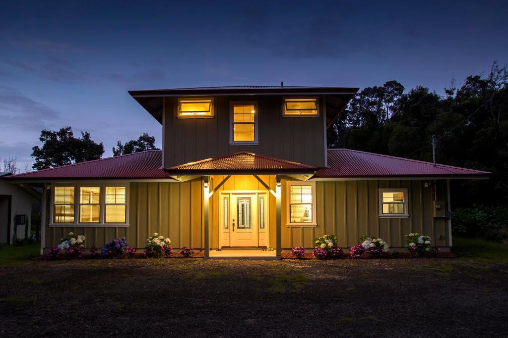 a house with a yellow door and lights on it at Kilauea House in Volcano