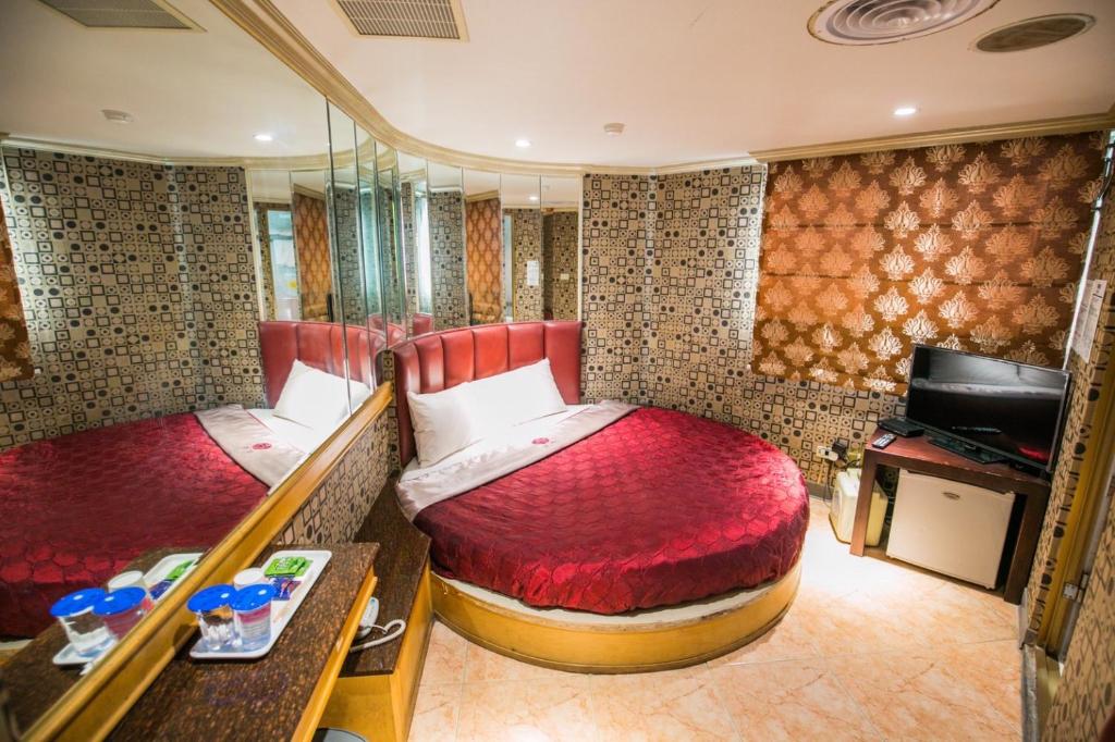 台北市にあるPai Yueh Hotelのベッド2台とテレビ付きのトレインルーム