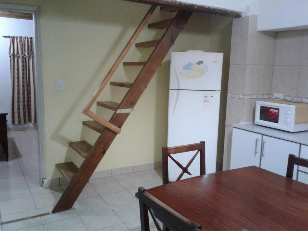 escalera en una cocina con mesa y nevera en San martin 304 en Balcarce